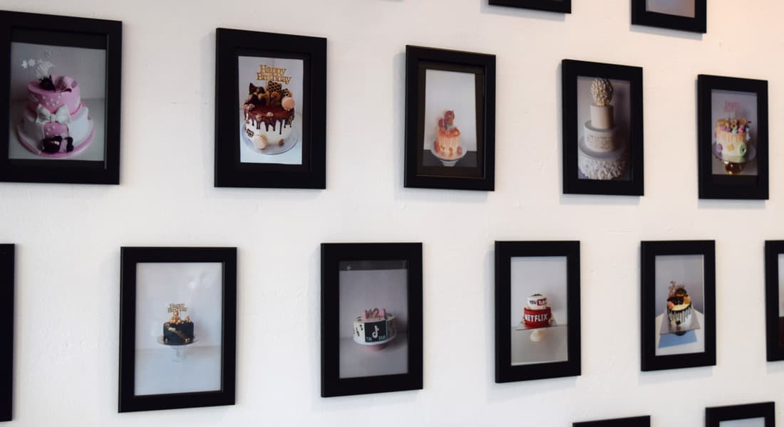 Wand mit gerahmten Fotos verschiedener Torten